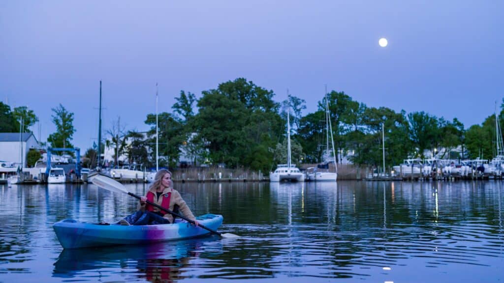 person in a kayak under the full moon