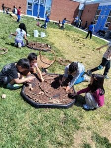 Children explore soil on their schoolyard during the SOLE Program.
